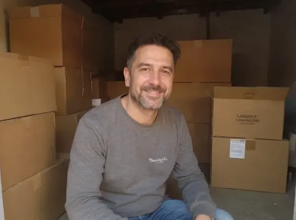 Hombre en su casa junto a las cajas de su pedido importado